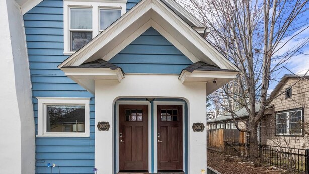 A two-story house with a blue exterior and a white porch. - DOG FRIENDLY & EPIC Location! Walk 2 Blocks to Hyde Park | Cozy Up by the Fireplace! (Boise)