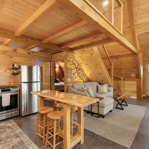 A cozy log cabin interior with a kitchen, dining area, and living space.