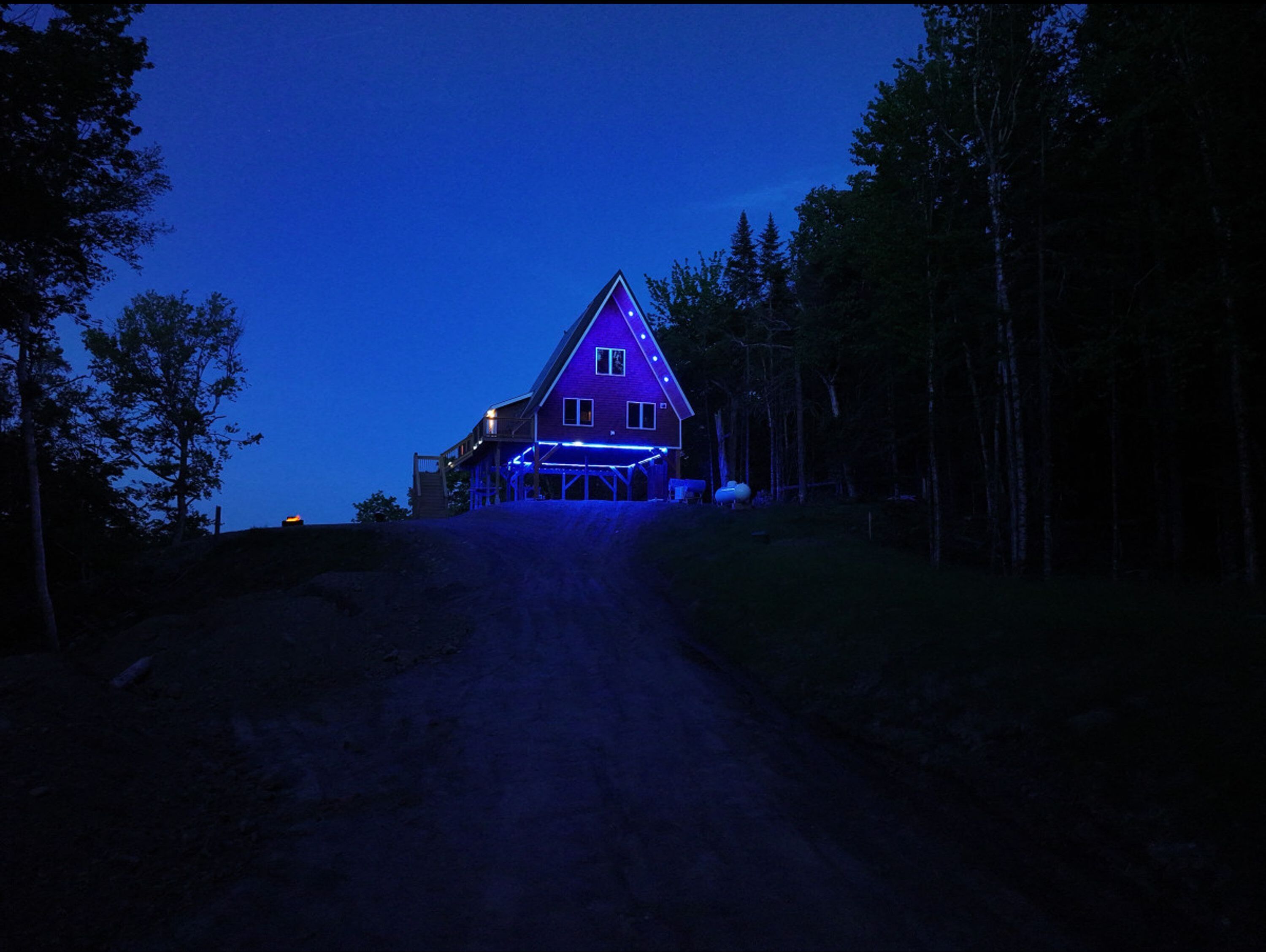 A house with a sloped roof, a front porch, and a driveway leading to the entrance.