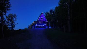 A house with a sloped roof, a front porch, and a driveway leading to the entrance.
