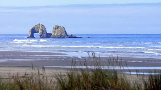 A beach with a natural rock formation.