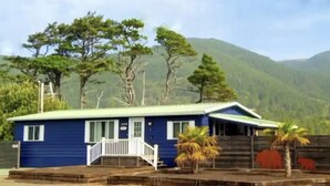 A single-story building with a blue exterior and a white porch.