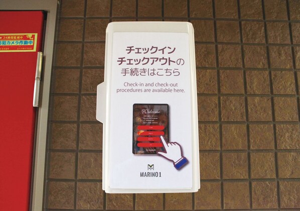 Un panneau avec du texte en japonais et une carte avec une bordure rouge, indiquant les procédures d’enregistrement à l’arrivée et au départ.