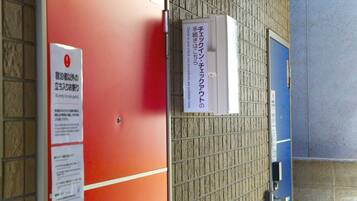 A room with a red door, a blue door, and a sign with Japanese text.
