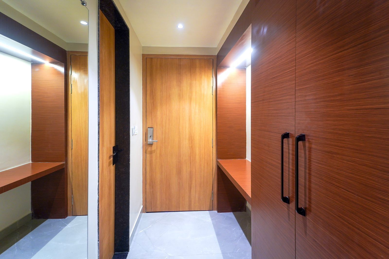 Un couloir avec des casiers en bois et une porte donnant sur une pièce.