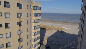 A high-rise building with multiple windows and balconies overlooking a beach. - Apartment in Nieuwpoort near the Beach (Nieuwpoort)