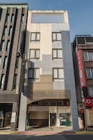 Een hotel met een moderne gevel, meerdere ramen en een opvallende entree.