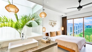 A modern bedroom with a large window, a bed, a vanity with a sink, and a ceiling fan. - Octo 6 Villa by Betterplace (Canggu)