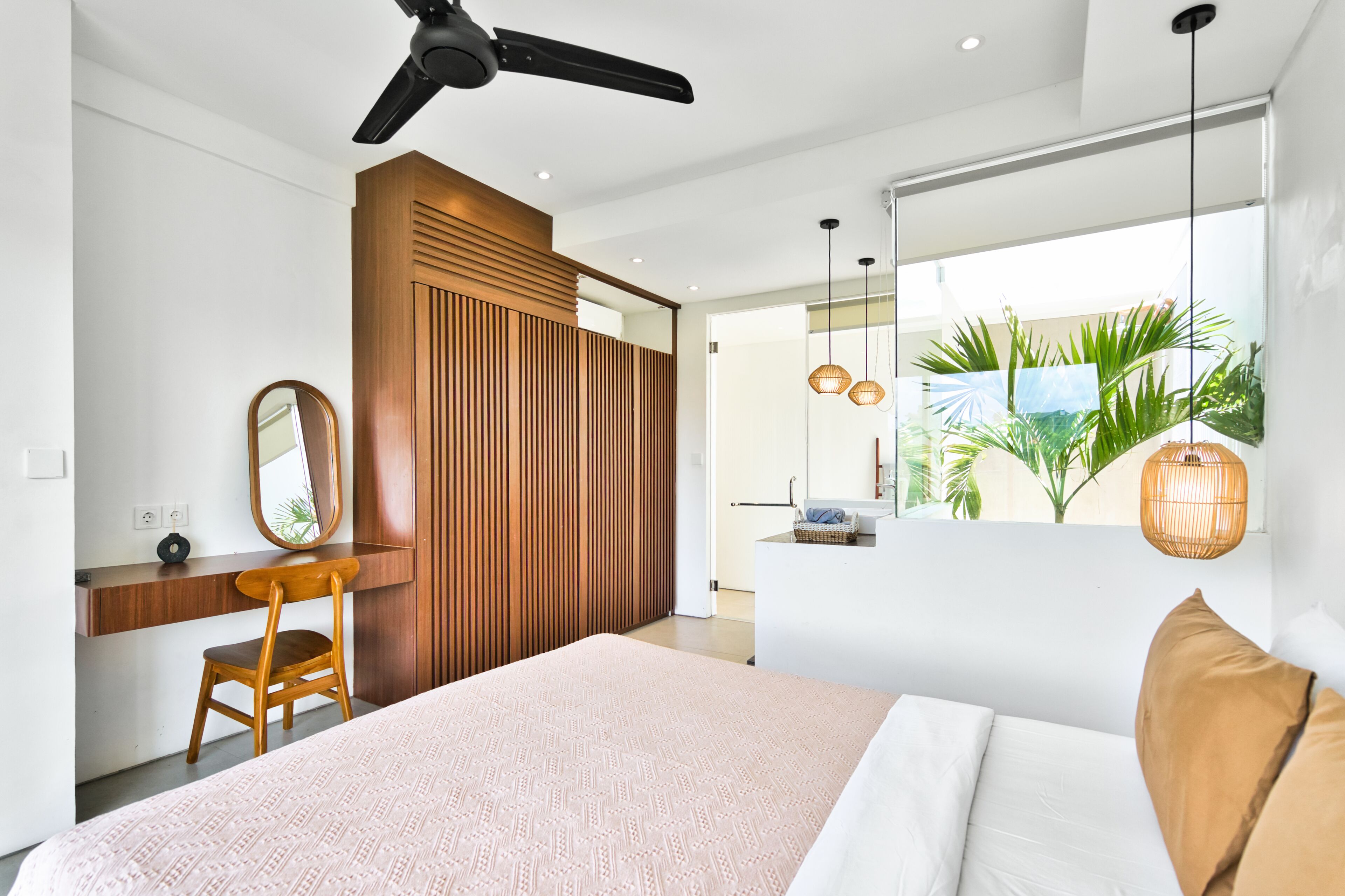 Un dormitorio moderno con cama, escritorio, silla y ventilador de techo.
