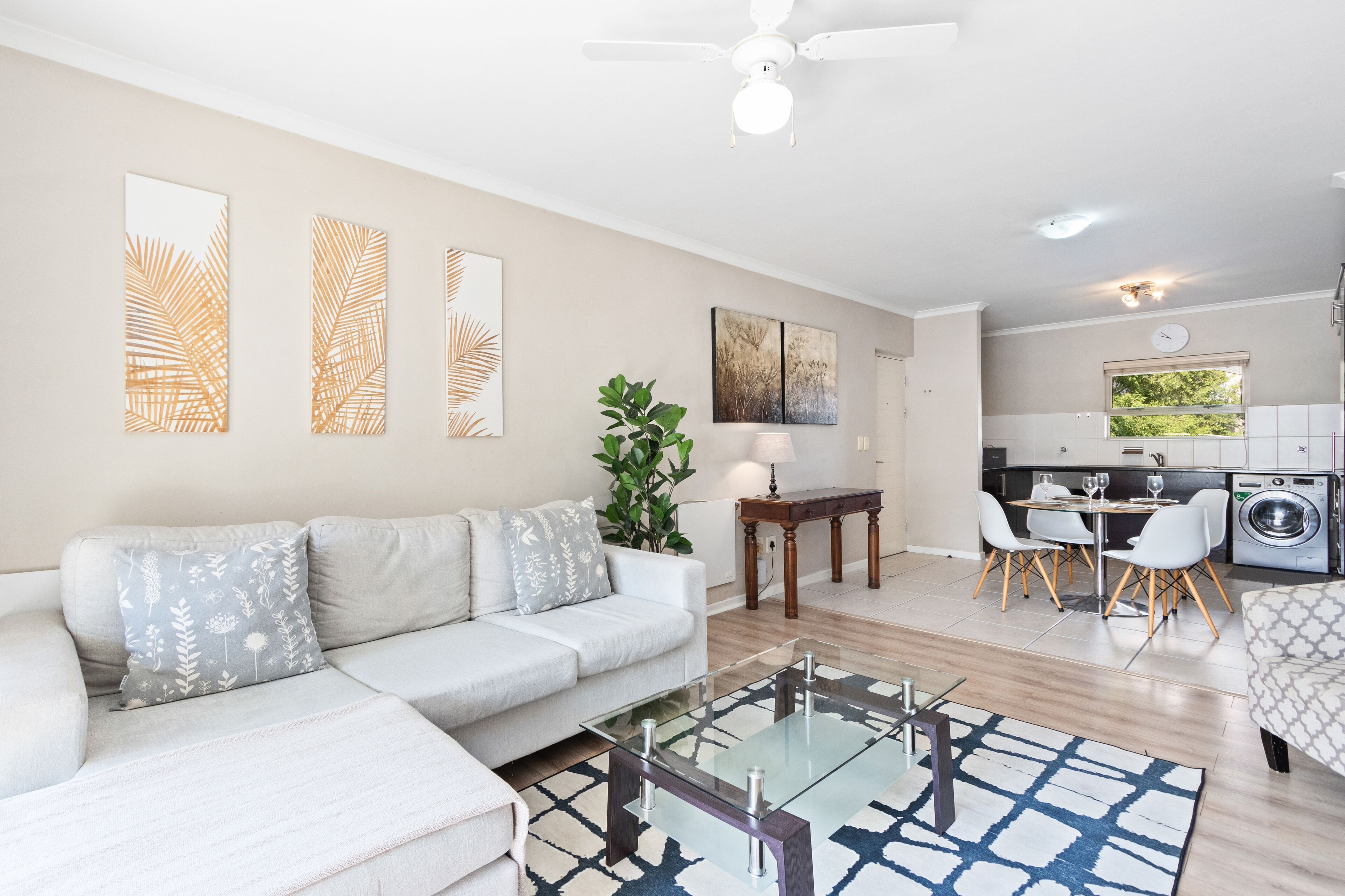 A modern living room with a sofa, coffee table, and artwork on the walls.