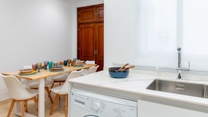 A modern kitchen with a white countertop, stainless steel sink, and wooden cabinets. - Pastor y Landero 17. 2-bedrooms. Arenal area (Sevilla)