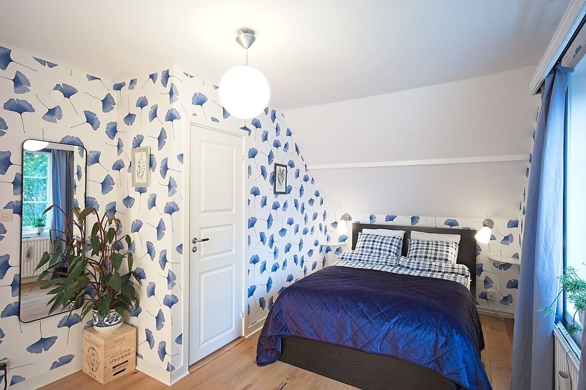 Ein Schlafzimmer mit einem Bett, einem Schminktisch, einem Spiegel und einer Topfpflanze.