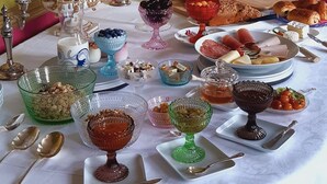 A table set with various food items, including fruits, cheeses, and pastries, arranged on a white tablecloth. - Le Château du Breuil (Mazières-de-Touraine)