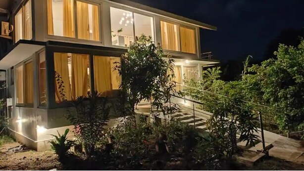Une maison moderne à deux étages, dotée d’un hall d’entrée bien éclairé et d’un escalier menant à la porte principale.
