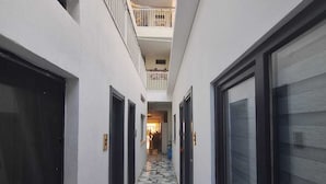 A narrow corridor with a tiled floor, white walls, and large windows on both sides. - SAND GARDEN (Bodrum)