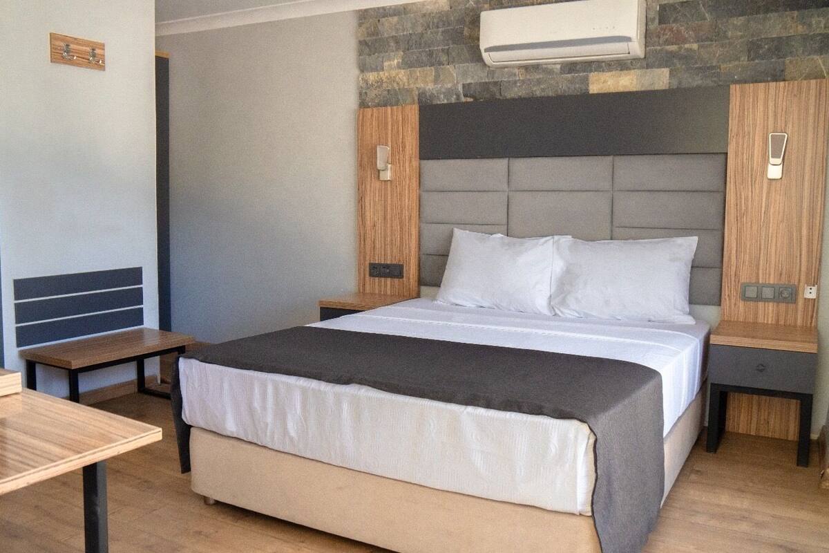 Une chambre moderne avec un lit, des tables de chevet et un appareil de climatisation.