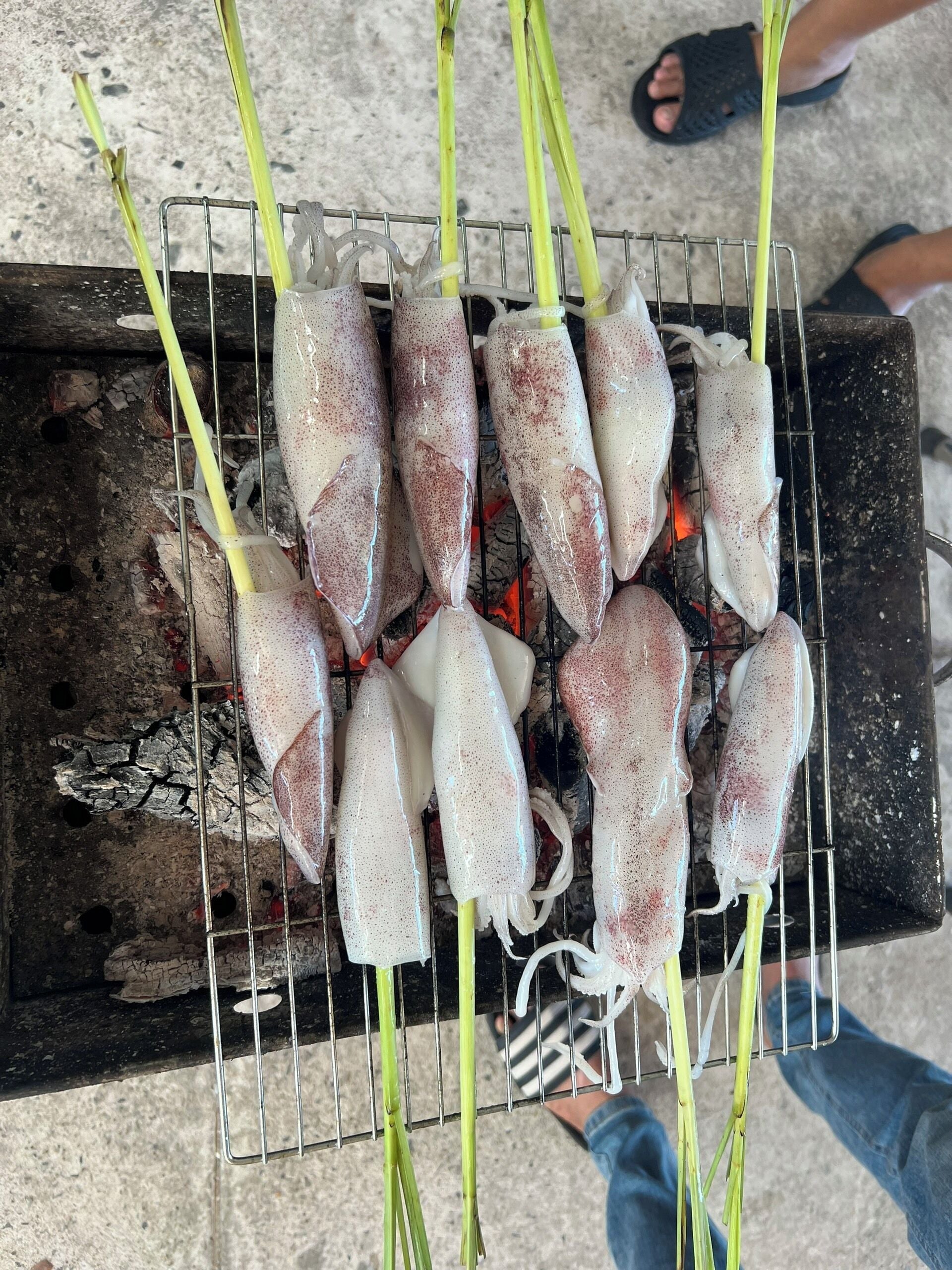 Una parrilla con calamares cocinándose.