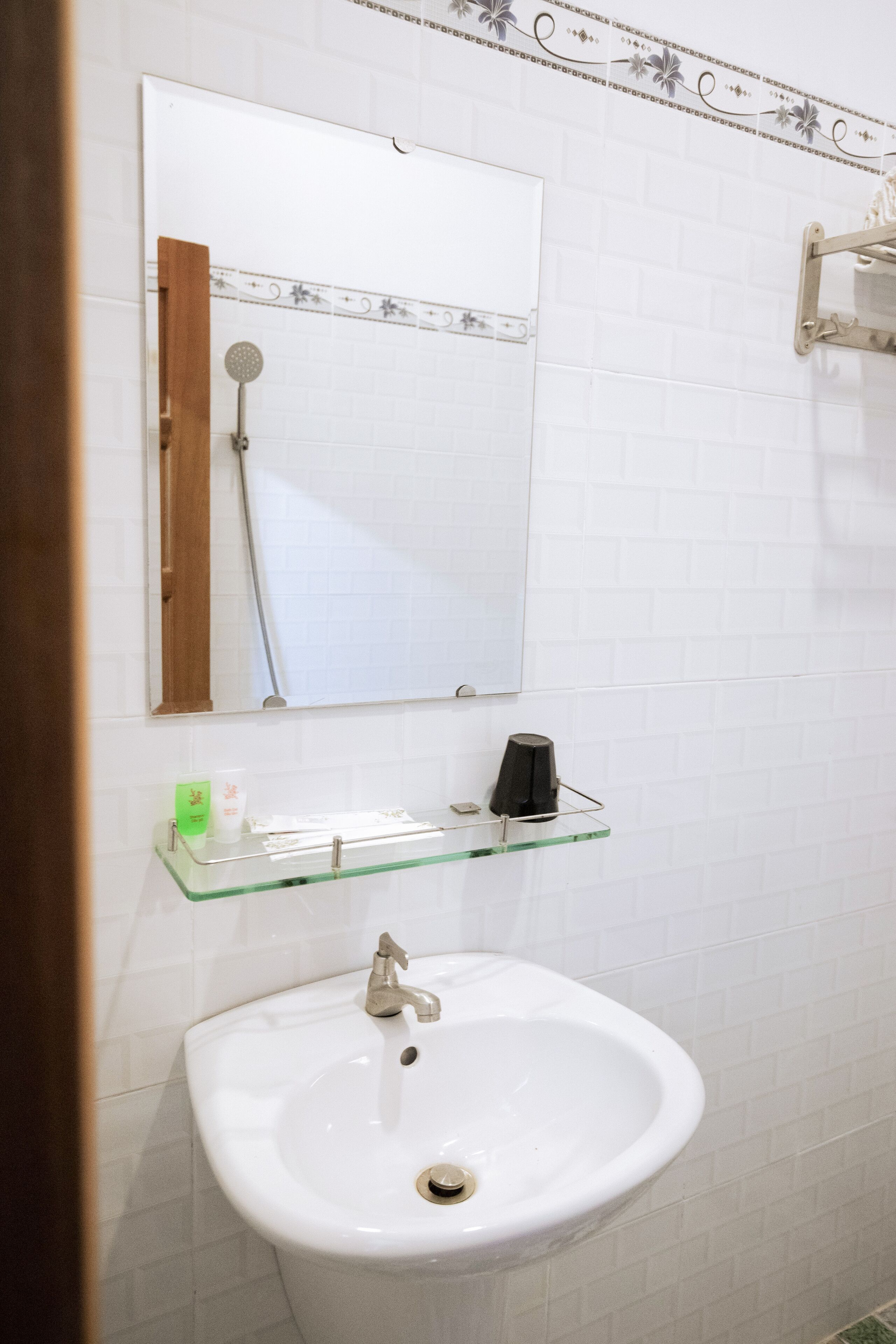 A bathroom with a white sink, a mirror, and a shower.