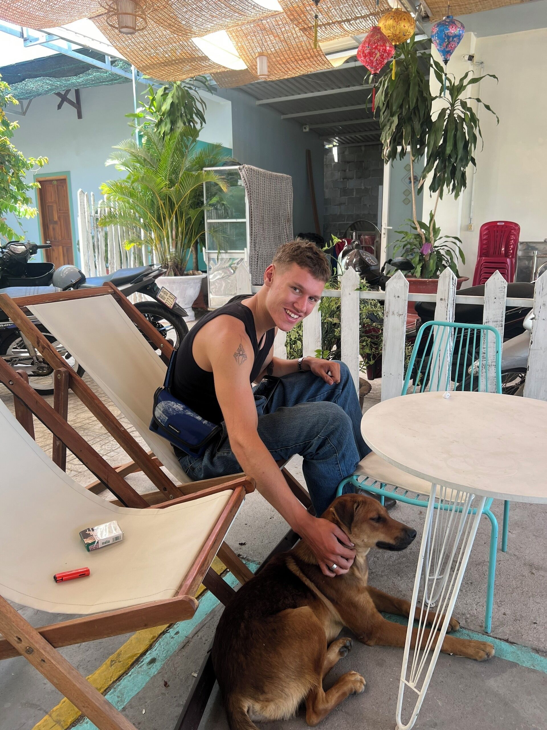 Une personne assise sur un banc en bois, avec un chien à ses côtés.