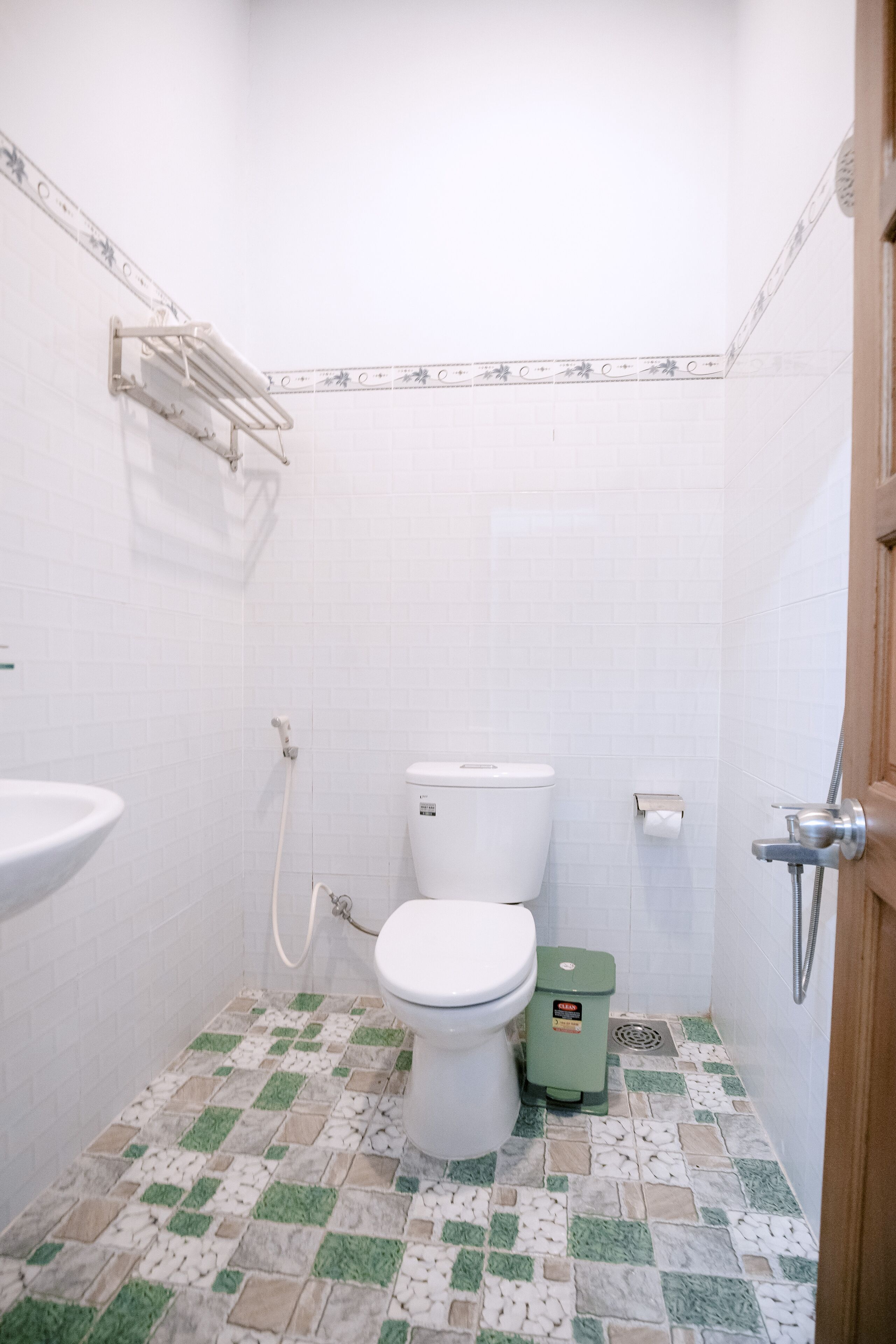 A small bathroom with a toilet, sink, and shower.