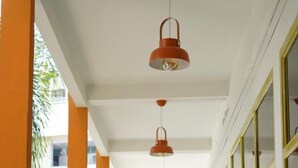 A corridor with orange walls, white ceiling, and a railing. - RoomQuest Hotel Pratunam (Bangkok)