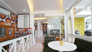 A modern interior with a kitchen area, a dining table with chairs, and a sofa. - RoomQuest Hotel Pratunam (Bangkok)