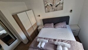 A neatly arranged bedroom with a bed, pillows, and a bedside table. - Apartment Antonio with balcony, near the beach (Kaštel Novi)