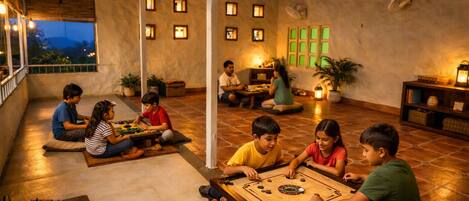Un grupo de niños jugando un juego de mesa en una habitación acogedora, bien iluminada, con piso de baldosas y vista al exterior.