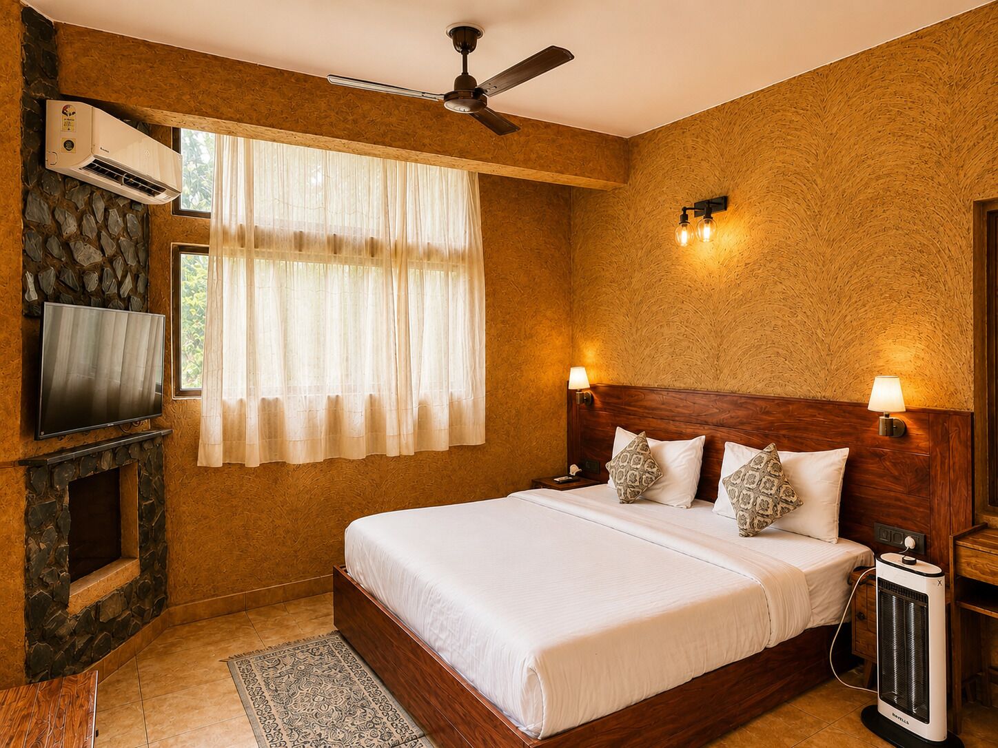 A hotel room with a bed, a television, an air conditioning unit, a ceiling fan, and a heater.