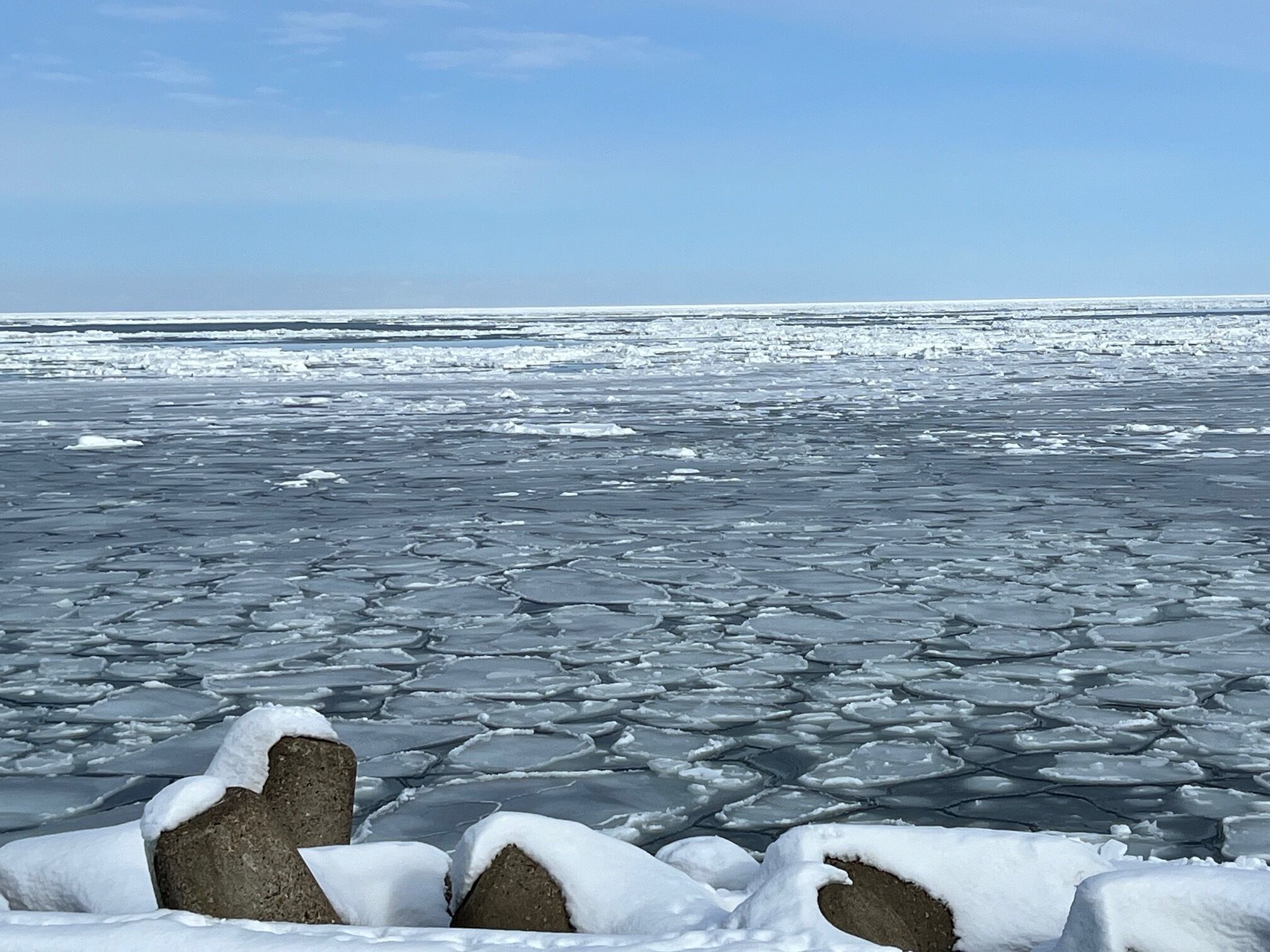 A frozen landscape with ice floes and rocks.