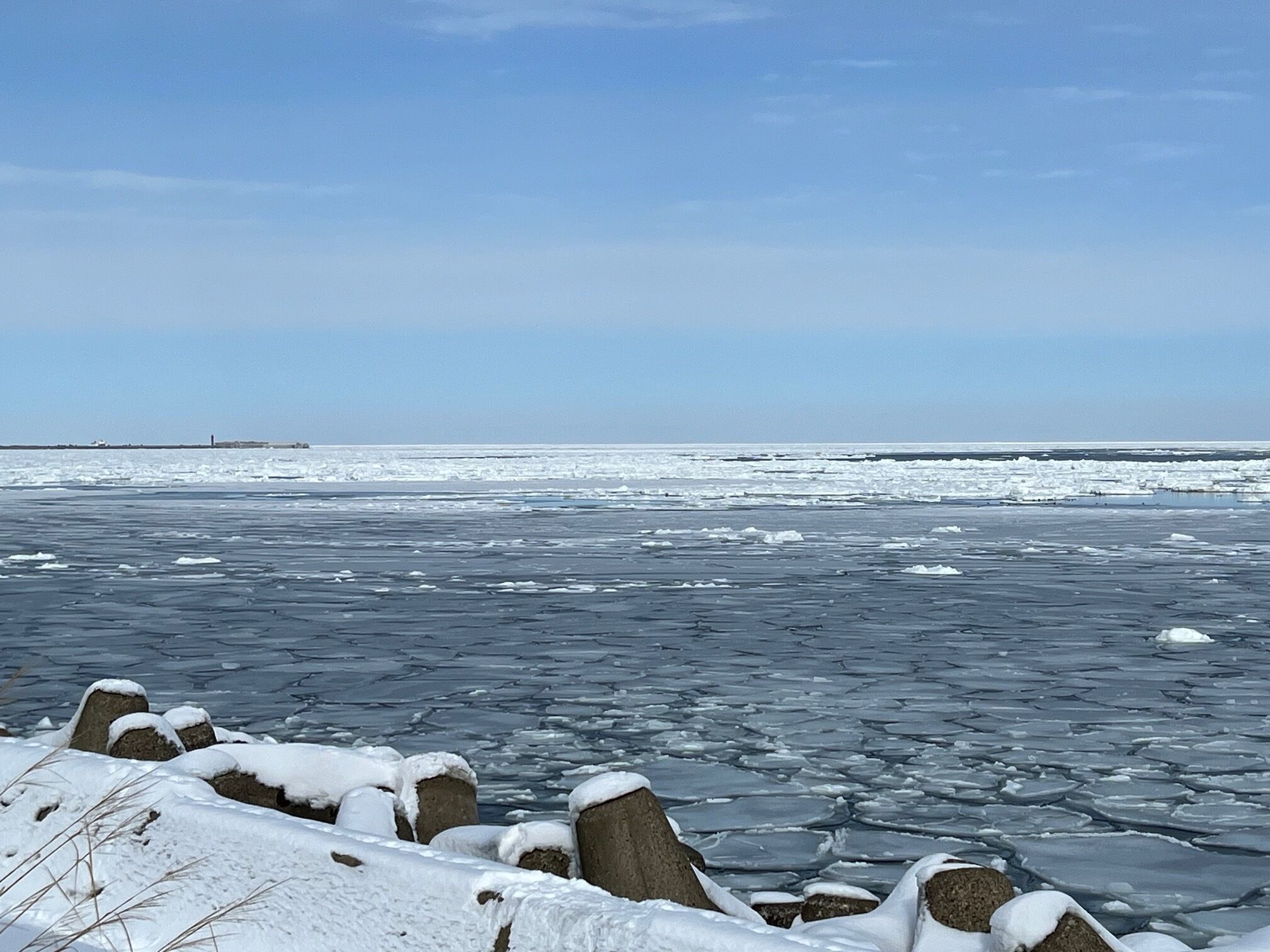 A frozen landscape with ice floes and snow-covered rocks.