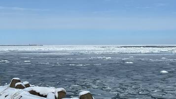 A frozen landscape with ice floes and snow-covered rocks.