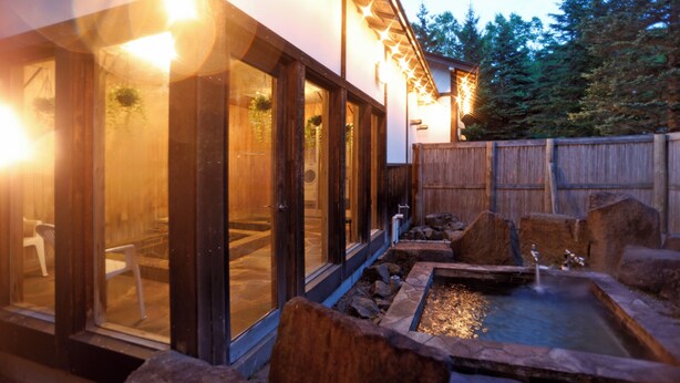 Ein Wellnessbereich mit Whirlpool, Holzterrasse und Holzzaun.