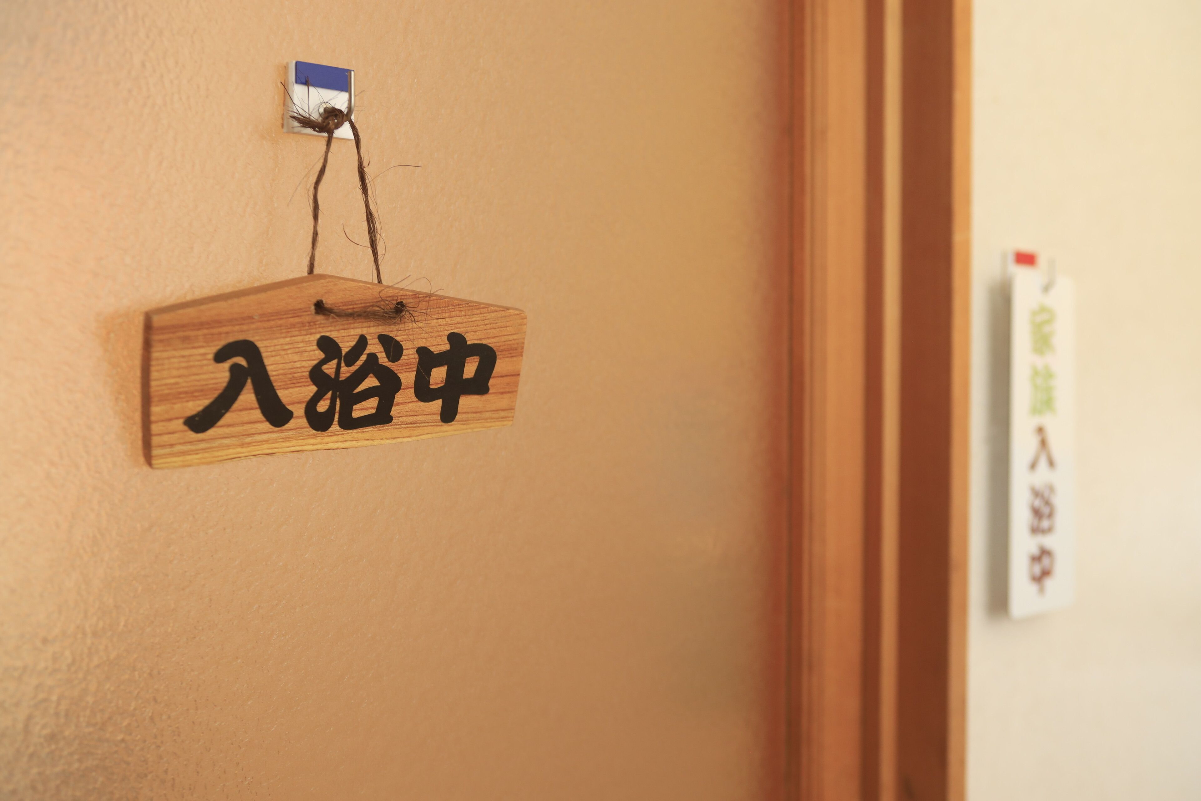 Un letrero de madera con caracteres chinos en una pared.