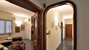 A hallway with a marble floor, a wooden door frame, and a light fixture. - Das Karma - Bruzzi (Genova)