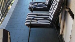A corridor with striped cushioned seating and a tiled floor. - Das Karma - Bruzzi (Genova)