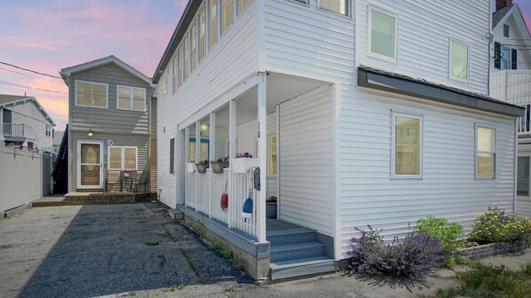 A two-story house with a covered porch and a front door. - Salt Life #2 by Bayley Vacation Rentals (Old Orchard Beach)