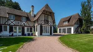 A traditional Tudor-style building with a gravel driveway leading to a white door. - Le Domaine de la Source (Pennedepie)