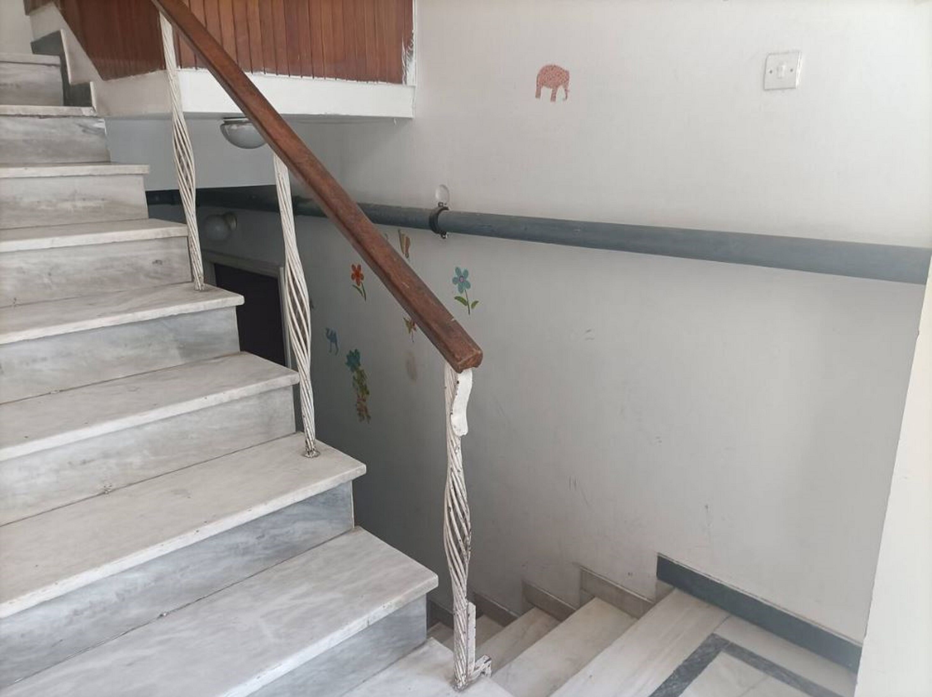 A staircase with white steps and a wooden handrail.