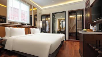 Una habitación de hotel con una cama grande, un tocador con espejo y una kitchenette.