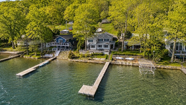 Une propriété au bord du lac comprenant plusieurs maisons, des quais et offrant une vue dégagée sur l’eau.
