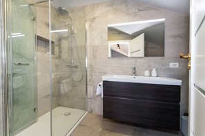 A modern bathroom with a glass shower enclosure, a dark vanity, and a mirror above the sink. - Villa Bruna ZadarVillas (Zadar)