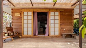 Un bâtiment en bois doté de portes coulissantes et d’un banc à l’extérieur.