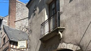 Il s’agit d’un bâtiment européen traditionnel, doté d’une façade en pierre, d’une cheminée bien visible et d’une enseigne indiquant qu’il s’agit d’un restaurant appelé « Le Châteaulet ».