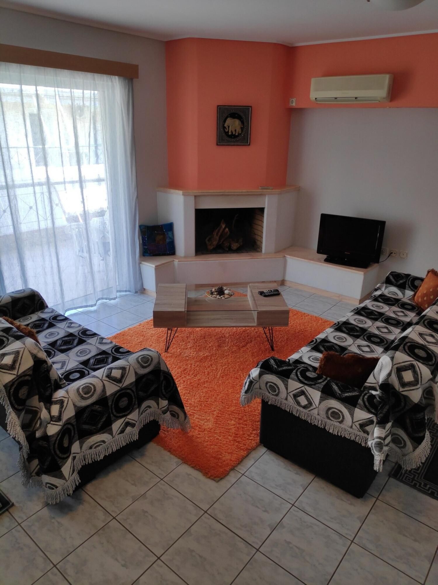 A living room with two sofas, a coffee table, a fireplace, and a television.
