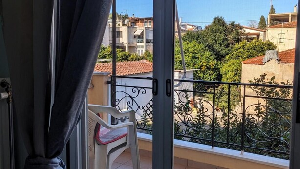 A balcony with a view of buildings and greenery. - Central Apartment in Agios Konstantinos (Kamena Vourla)