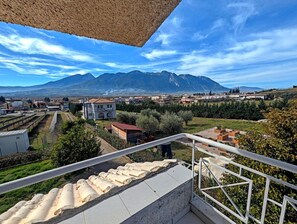 A balcony with a view of a town, mountains, and vineyards. - Ecoscape Luxury Villa Lamia (Lamia)