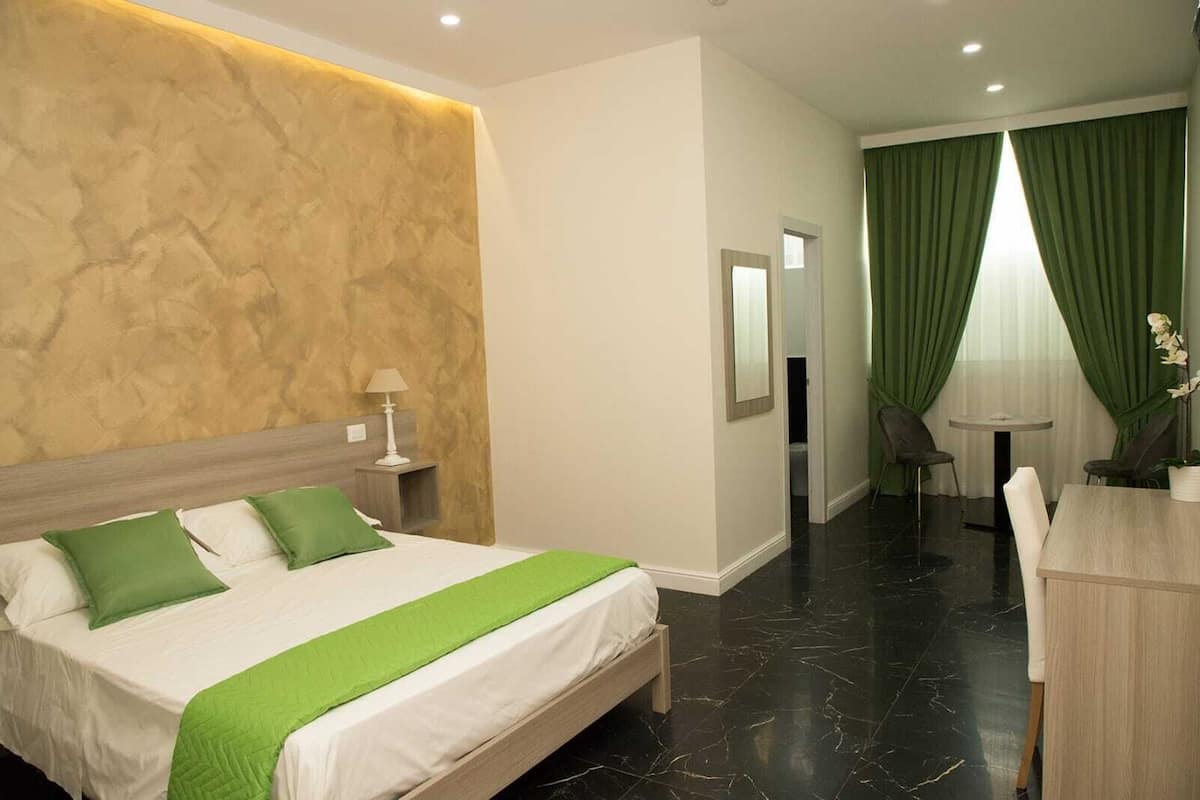 Une chambre d’hôtel avec un lit, un bureau et une chaise.