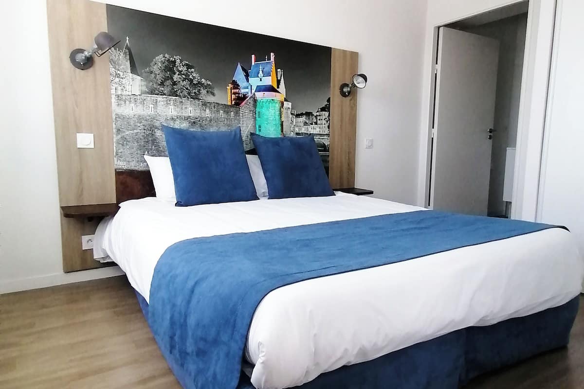 Ein Schlafzimmer mit einem Bett, einem an der Wand befestigten Regal und einer Tür.