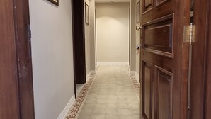 A hallway with patterned floor tiles, wooden doors, and recessed ceiling lights. - B&B Arcovito 36 (Reggio Calabria)